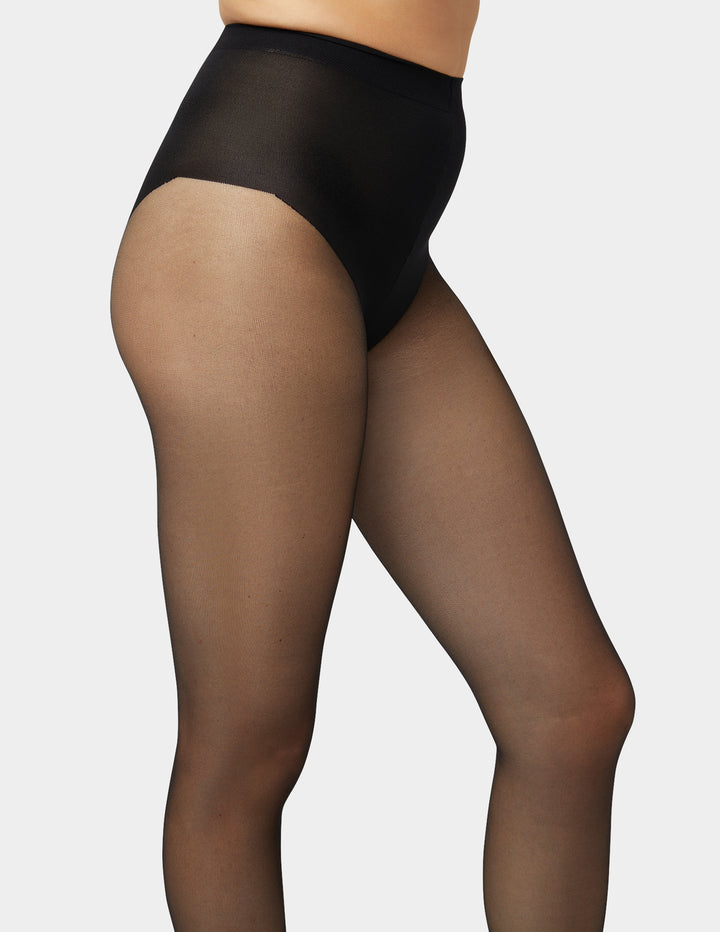 Black sheer tights worn by a model on a plain background