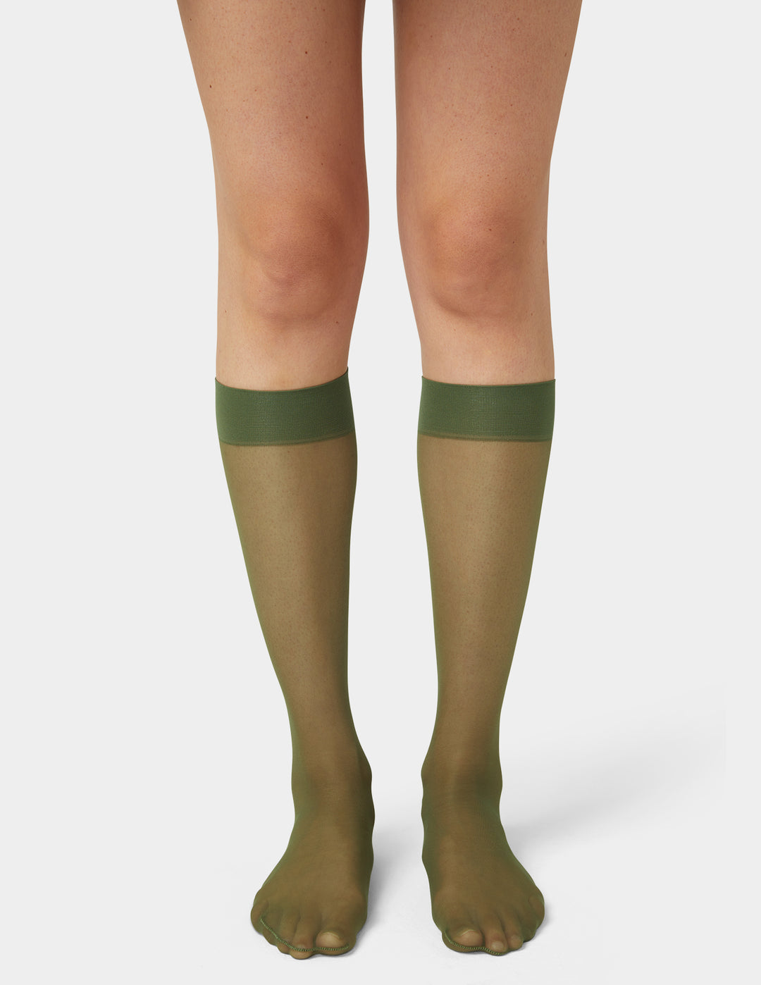 Green sheer knee-high socks worn by a person on a white background