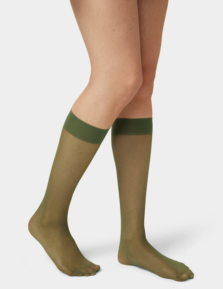 Green sheer knee highs worn by a person on a white background