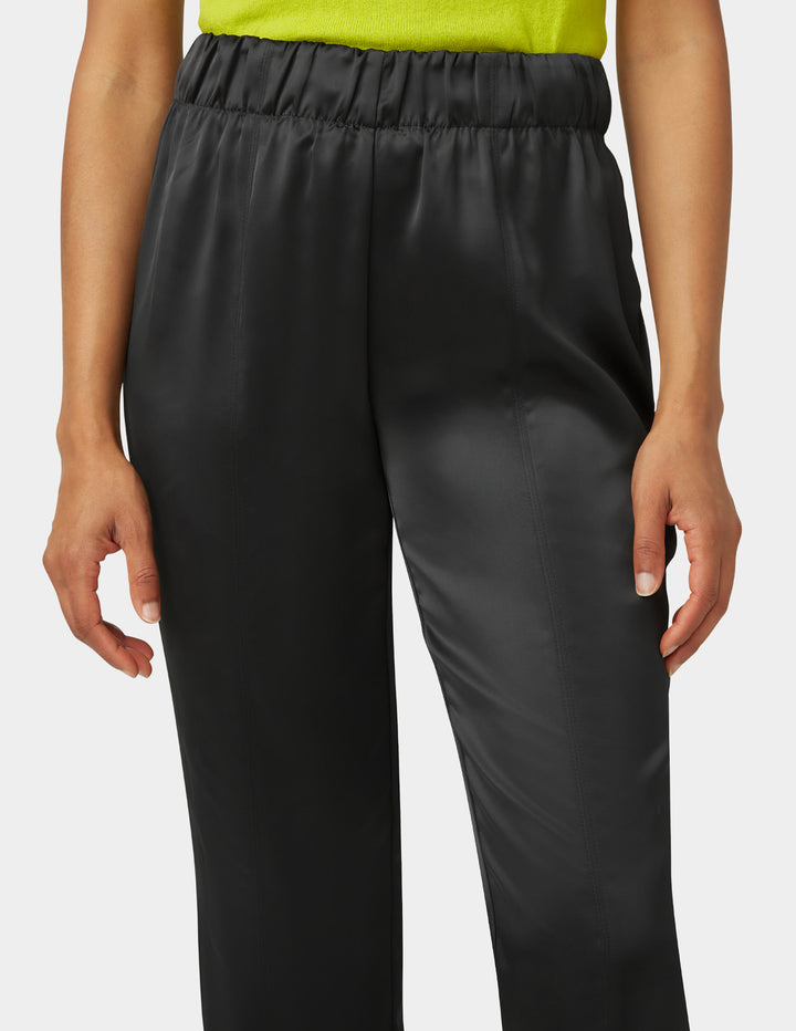 Black pants worn by a person on a white background