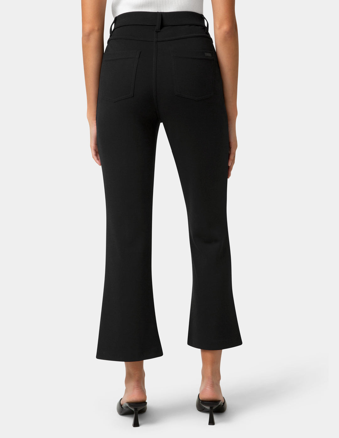 Black pants worn by a person on a white background