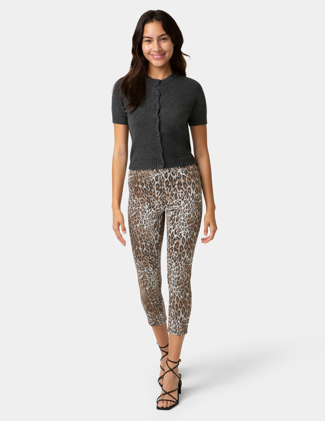 Woman wearing a black top and leopard print pants on a white background