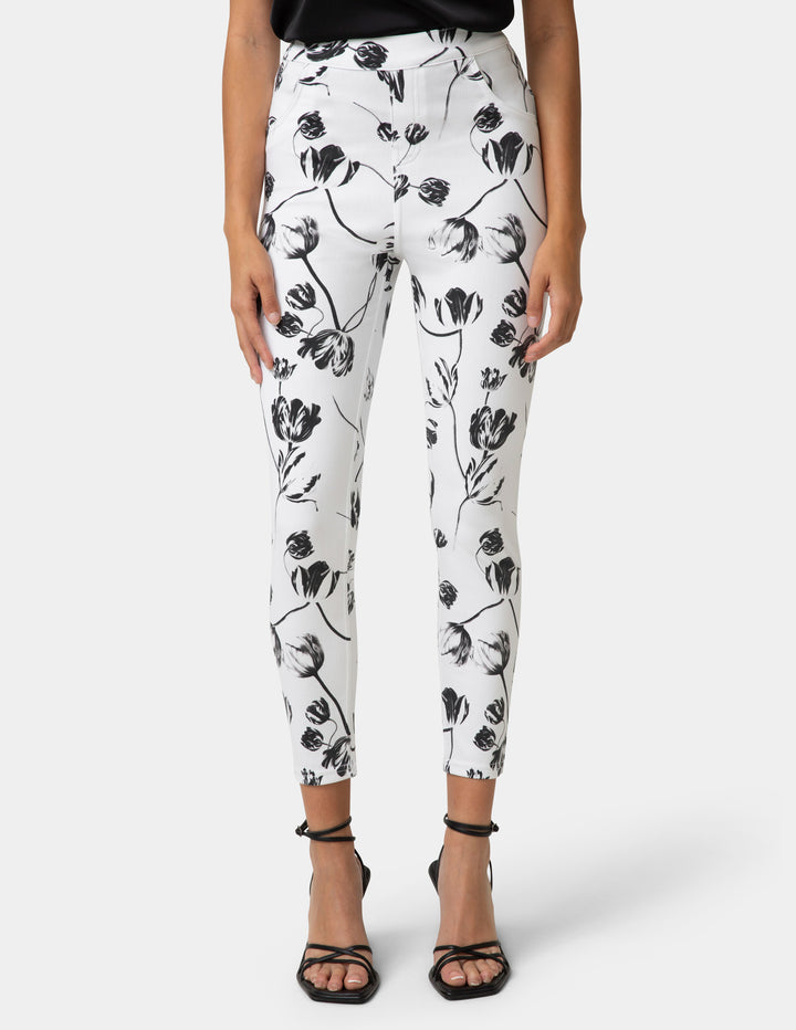 White pants with black floral pattern worn by a person on a white background