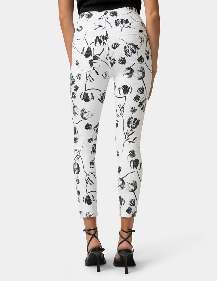 White pants with black floral pattern worn by a person on a white background