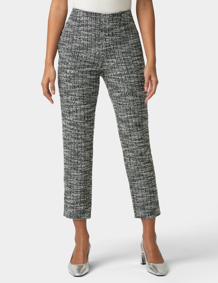 Person wearing black and white patterned pants on a white background