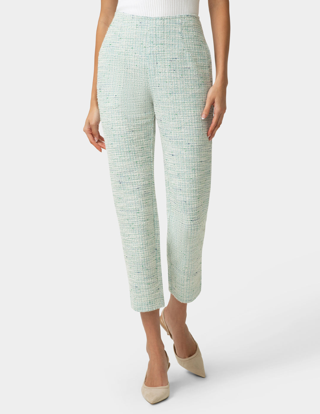 Person wearing mint green textured pants on a white background