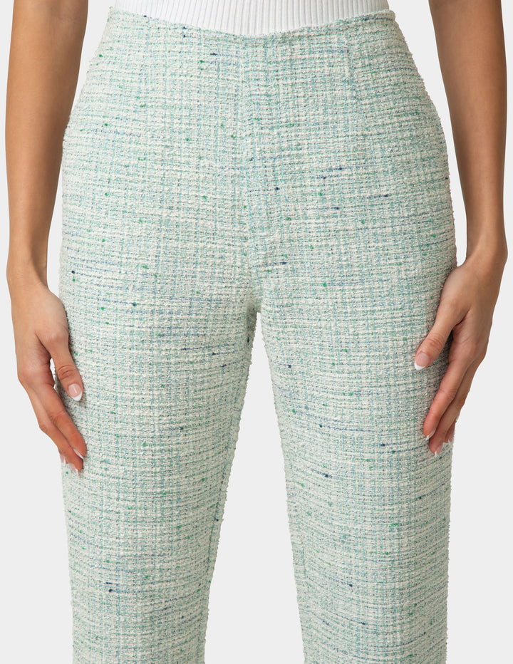 Green textured pants worn by a person on a white background