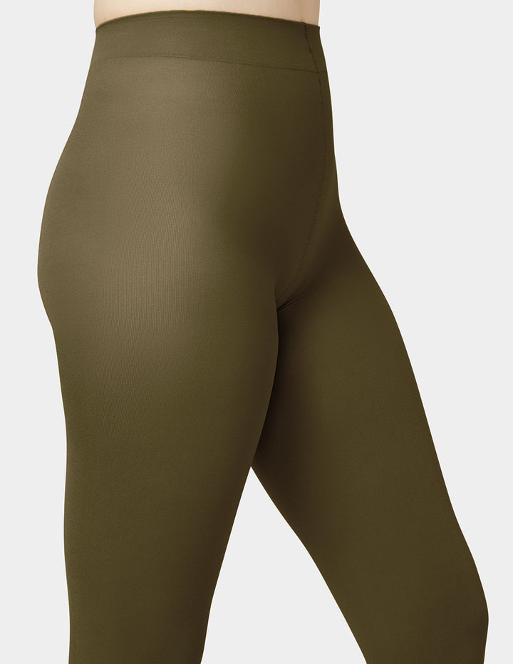 Close-up of a person wearing high-waisted olive green tights against a light gray background.